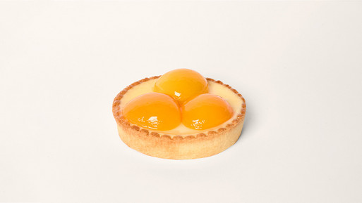 Edles Aprikosen-Tartelette, goldbrauner Mürbteig Boden mit glänzenden Aprikosen – ein sonnig-fruchtiger Genussmoment aus der Breuninger Confiserie.