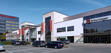 Außenansicht des Breuninger Gebäudes in Sindelfingen mit Eingangsbereich und geparkten Autos bei Tageslicht