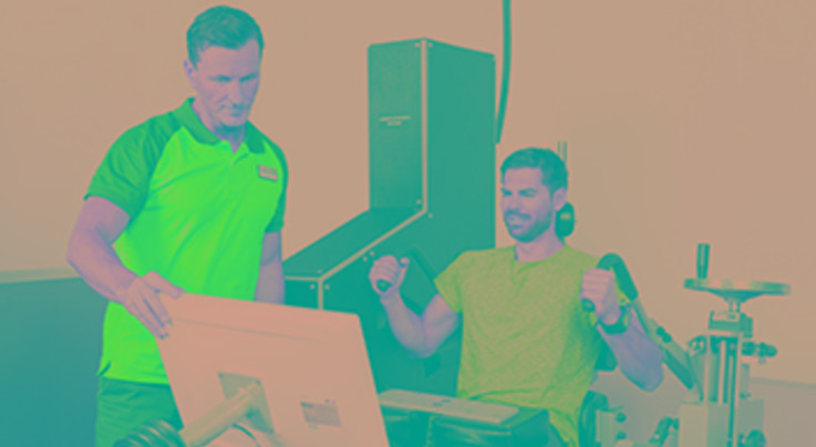 Das Bild zeigt 2 Sportler, die Trainingsgeräte testen.