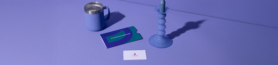 Blaue Kerze, blaue Tasse, Geschenkkarte, lilafarbener Hintergrund.