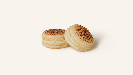 Zwei feine Crème Brûlée Macarons mit einer cremefarbenen, zarten Schale, veredelt durch karamellisierte Zuckerkruste. Gefüllt mit einer cremigen Crème Brûlée-Ganache, verbinden sie süßen Genuss mit einem Hauch von Eleganz – hergestellt mit höchster Sorgfalt und Qualität aus der Breuninger Confiserie.
