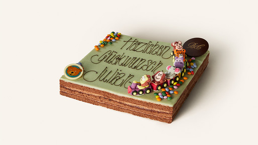 Eine liebevoll gestaltete rechteckige Torte aus der Breuninger Confiserie, die Kinderherzen höherschlagen lässt. Die Oberfläche ist mit zartgrünen Fondant überzogen und trägt in feiner, geschwungener Schrift die Aufschrift „Herzlichen Glückwunsch Julian“. Das Highlight der Dekoration ist eine bunte, aus Zuckermasse modellierte Tierzug-Szene, die fröhlich über die Torte fährt, begleitet von bunten Schokolinsen. Ein kleines Schokoladenschild mit den goldenen Initialen „BC“, das für die hohe Qualität der Breuninger Confiserie steht, rundet die Gestaltung ab. Diese Torte ist ein wahrer Blickfang, perfekt für besondere Geburtstagsfeiern.