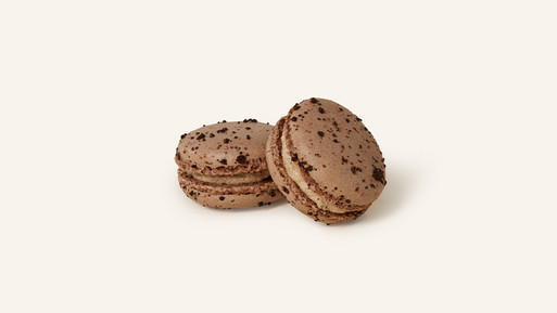Zwei Pekannuss-Macarons mit einer schokoladenbraunen Schale, die den nussigen Charakter perfekt widerspiegelt. Gefüllt mit einer cremigen Pekannuss-Ganache, vereinen sie den intensiven Geschmack der Pekannuss mit handwerklicher Perfektion – ein erlesener Genuss aus der Breuninger Confiserie.