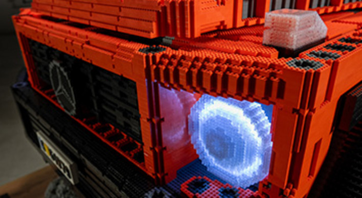 Orangene Mercedes G Klasse in der Nahaufnahme aus Legosteinen gebaut.
